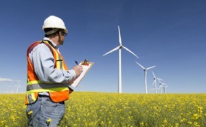image of a wind farm and an inspection man wearing a hard hat and safety vest